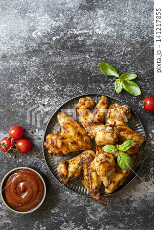 Barbecue chicken wings with sauce on a stone surface. Traditional baked bbq buffalo. Tasty snack for beer. Top view flat lay background. Copy space. 141217855