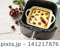 Homemade cottage cheese casserole with cherries in kitchen gadget modern air fryer on wooden background. perfect for breakfast or a snack. Copy space. 141217876