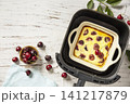 Homemade cottage cheese casserole with cherries in kitchen gadget modern air fryer on wooden background, perfect for breakfast or a snack. Top view flat lay background. Copy space. 141217879