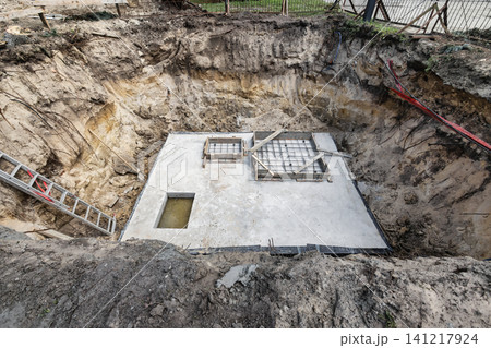 Workers are placing metal rebar in position to reinforce the concrete before it is poured into the foundation at the construction location 141217924