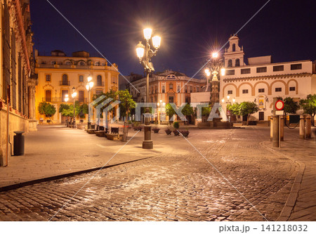 Night view of Plaza del Salvador in Seville, Spain, featuring illuminated historic buildings, traditional street lamps, and a quiet city square in the historic center. Night view of Plaza del Salvador in Seville, Spain, featuring illuminated historic buildings, traditional street lamps, and a quiet city square in the historic center. 141218032