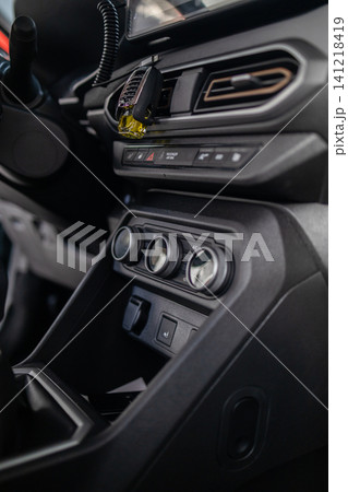 Close up of vehicle interior center dashboard layout, climate system, and manual gearbox. Close up of vehicle interior center dashboard layout, climate system, and manual gearbox. 141218419