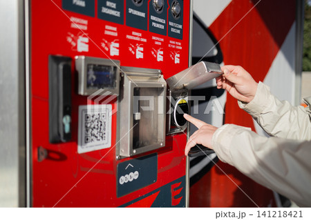 Hand paying with coin at automated vending machine of manual carwash. Hand paying with coin at automated vending machine of manual carwash. 141218421