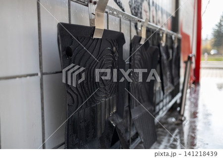 Rubber vehicle mats clipped on a wall rack before washing at manual car wash. Rubber vehicle mats clipped on a wall rack before washing at manual car wash. 141218439