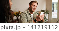 Image of handsome young man in cafe, looking at his mobile phone, using smartphone app, drinking coffee 141219112