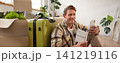 Portrait of smiling handsome tourist, man holding passport and flight tickets, sitting with suitcase 141219116