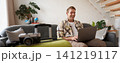 Portrait of happy young man, tourist booking his holiday with travel agency, looking at laptop, packed suitcase to go on vacation 141219117