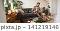 Man with a dog sitting near suitcase, holding notebook, checking list of items to take on vacation, planning a holiday trip 141219146
