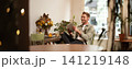 Portrait of happy, relaxed young man sitting in cafe alone, wearing wireless headphones, playing video game on tablet, laughing and smiling, looking at his device. Concept of lifestyle and people 141219148