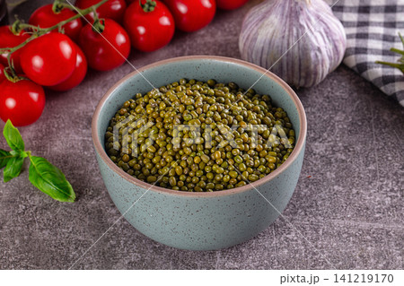 Bowl of green mung beans with cherry tomatoes and garlic on rustic surface Bowl of green mung beans with cherry tomatoes and garlic on rustic surface 141219170