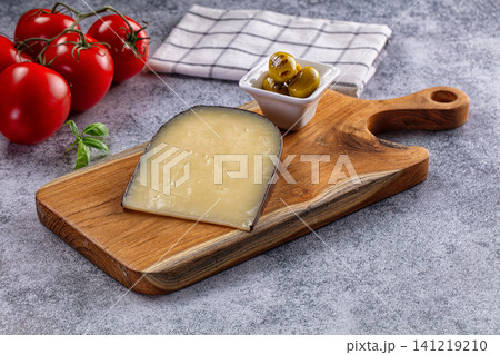 Cheese wedge on wooden board with tomatoes and olives Cheese wedge on wooden board with tomatoes and olives 141219210