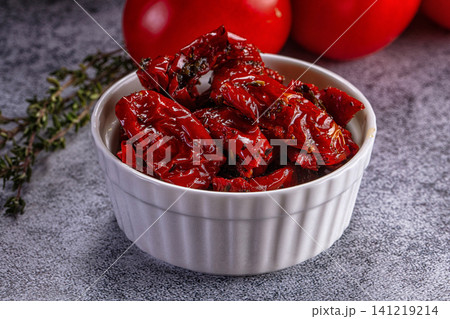 Sun dried tomatoes in white ceramic bowl with fresh thyme and whole tomatoes Sun dried tomatoes in white ceramic bowl with fresh thyme and whole tomatoes 141219214