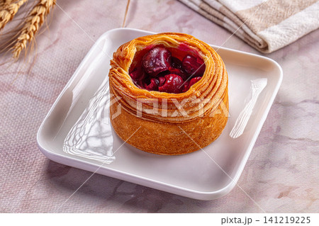 Cherry pastry on white plate with wheat stalks and linen napkin Cherry pastry on white plate with wheat stalks and linen napkin 141219225