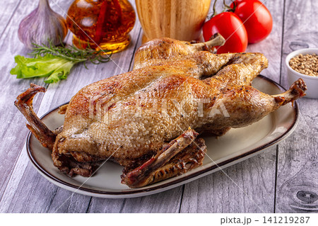 Roasted duck with herbs and vegetables on rustic wooden table 141219287