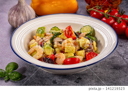 Shrimp and vegetable medley in ceramic bowl with fresh basil and garlic 141219323