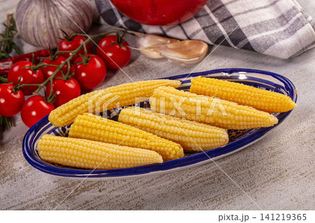 Fresh corn on cob with cherry tomatoes and garlic on rustic plate Fresh corn on cob with cherry tomatoes and garlic on rustic plate 141219365