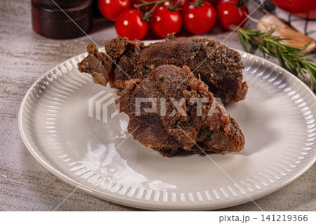 Braised beef cheek on white plate with cherry tomatoes and rosemary 141219366