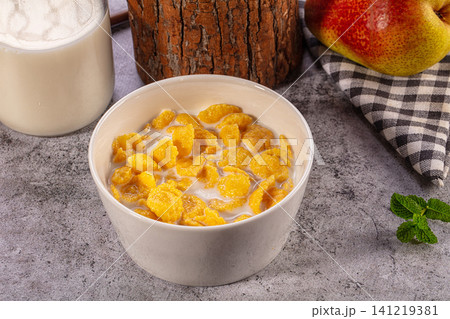 Bowl of Cornflakes with Milk and Fresh Pear on Rustic Table Bowl of Cornflakes with Milk and Fresh Pear on Rustic Table 141219381