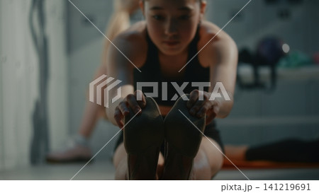 Teen Gymnast Practicing Seated Forward Fold Bending in Dressing Room Teen Gymnast Practicing Seated Forward Fold Bending in Dressing Room 141219691