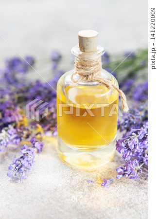 Lavender flowers surrounding a bottle of natural essential oil 141220009