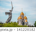 Iconic view of The Motherland Calls statue alongside the Church of All Saints on Mamayev Kurgan. The scene reflects the blend of Soviet history and Russian Orthodox 141220182