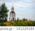 Volgograd, Russia - 05.23.2023: Serene historic church with golden dome nestled in vibrant green foliage, evoking peace and cultural heritage 141220184