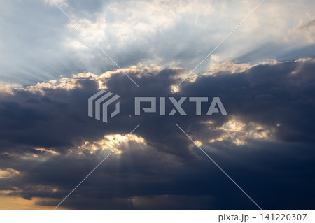 Dark clouds with sun rays breaking through sky Dark clouds with sun rays breaking through sky 141220307
