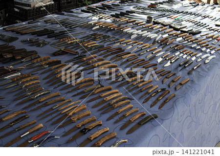 XALO, SPAIN - JUNE 20, 2026.Collectors browse through a wide selection of pocket knives and folding knives with wooden handles arranged on a blue tablecloth at a market. The atmosphere is busy with tr XALO, SPAIN - JUNE 20, 2026.Collectors browse through a wide selection of pocket knives and folding knives with wooden handles arranged on a blue tablecloth at a market. The atmosphere is busy with tr 141221041
