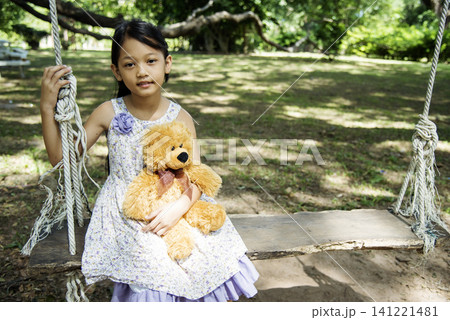Happy Child hug teddy bear in green park playground. Teddy bear best friend for little kids cute girl. Autism happy funny playing together on playground in happiness family feel love and warm hugs Happy Child hug teddy bear in green park playground. Teddy bear best friend for little kids cute girl. Autism happy funny playing together on playground in happiness family feel love and warm hugs 141221481