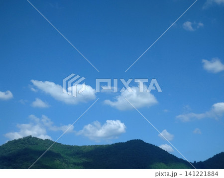 白い夏雲と青空が映える緑豊かな山並みの風景 141221884