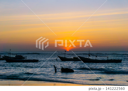 Sunset beach in Indonesia with golden waves and pristine white sand capturing tropical beauty and serene coastal atmosphere Sunset beach in Indonesia with golden waves and pristine white sand capturing tropical beauty and serene coastal atmosphere 141222560