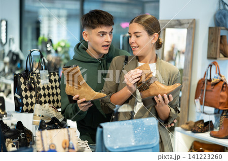 Couple man and woman choosing ankle boots in store 141223260