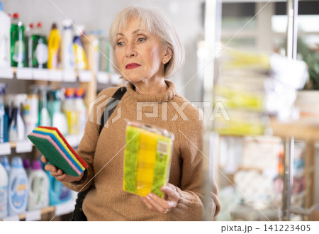 Elderly woman choosing sponges to wash Elderly woman choosing sponges to wash 141223405