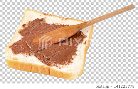 A slice of white toast bread with sweet chocolate hazelnut spread being applied using a wooden spatula. Isolated. Perfect for breakfast or snack concepts. A slice of white toast bread with sweet chocolate hazelnut spread being applied using a wooden spatula. Isolated. Perfect for breakfast or snack concepts. 141223779