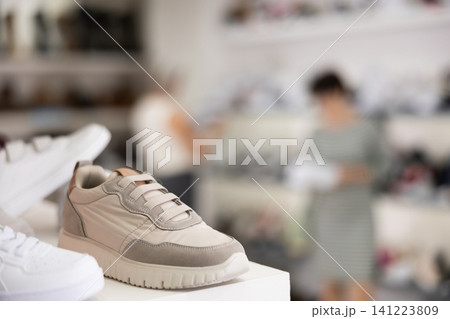 There are sneakers and sports shoes on shelf in store There are sneakers and sports shoes on shelf in store 141223809