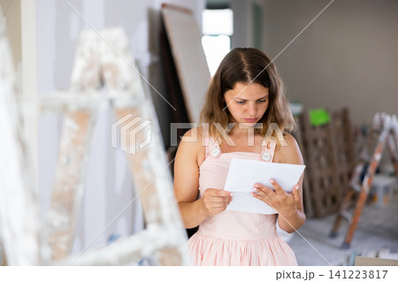 Woman construction manager checking project documentation Woman construction manager checking project documentation 141223817