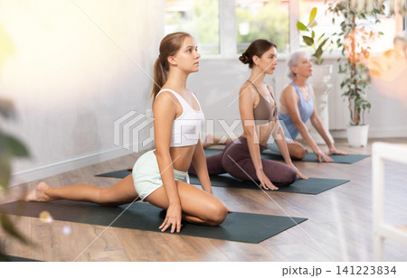 Teenage girl practicing seated stretching asana Ardha Kapotasana Teenage girl practicing seated stretching asana Ardha Kapotasana 141223834