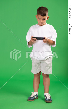 Preschooler boy plays online games or scrolling smartphone Preschooler boy plays online games or scrolling smartphone 141223858