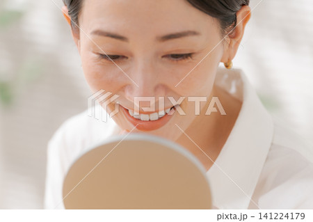 鏡で口を見る女性 鏡で口を見る女性 141224179