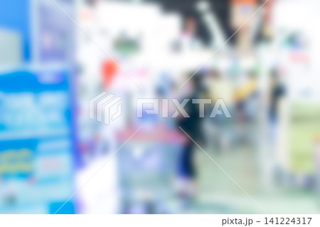 Defocused supermarket checkout area shopping carts retail shelves customers bright indoor lighting creating an abstract commercial background for business consumer themes 141224317