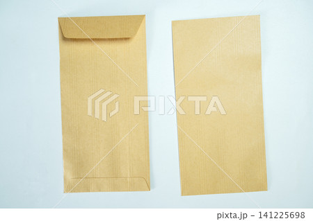 Top-down view of two blank brown kraft paper envelopes arranged on a light blue textured background, perfect for stationery mockups Top-down view of two blank brown kraft paper envelopes arranged on a light blue textured background, perfect for stationery mockups 141225698