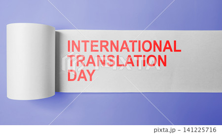Minimalist conceptual banner for International Translation Day, featuring red text revealed on an unrolled white paper roll over a purple background 141225716