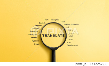 A top-down view of a black magnifying glass focusing on the word translate, surrounded by names of different languages written in their native scripts on a solid yellow background A top-down view of a black magnifying glass focusing on the word translate, surrounded by names of different languages written in their native scripts on a solid yellow background 141225720