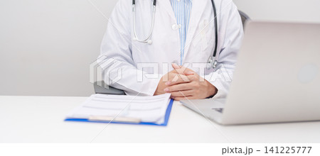 Professional doctor wearing lab coat using laptop and taking report notes on notebook for November Lung Cancer Awareness month, World Cancer Day and oncology healthcare concept in hospital 141225777