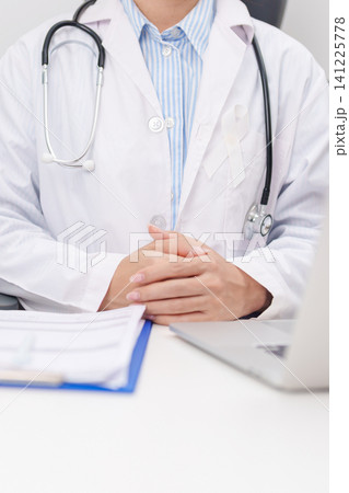 Professional doctor wearing lab coat using laptop and taking report notes on notebook for November Lung Cancer Awareness month, World Cancer Day and oncology healthcare concept in hospital Professional doctor wearing lab coat using laptop and taking report notes on notebook for November Lung Cancer Awareness month, World Cancer Day and oncology healthcare concept in hospital 141225778