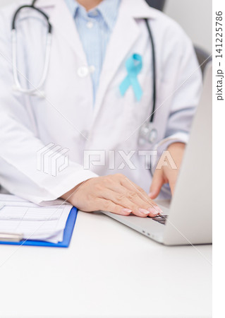 doctor using laptop and report notes on notebook. blue Ribbon concept of November Prostate Cancer Awareness month, Diabetes day , Men Health, International men, Father day. world cancer day doctor using laptop and report notes on notebook. blue Ribbon concept of November Prostate Cancer Awareness month, Diabetes day , Men Health, International men, Father day. world cancer day 141225786