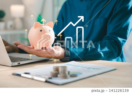 Financial investment and wealth increase shown with person holding piggy bank, business worker planning budget using laptop and analyzing positive trend with growing graph and coins 141226139