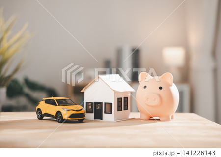 Pink piggy bank sits beside white house model and yellow car on wooden table, money saving and planning help property purchase, residential mortgage ensures real estate invest success Pink piggy bank sits beside white house model and yellow car on wooden table, money saving and planning help property purchase, residential mortgage ensures real estate invest success 141226143