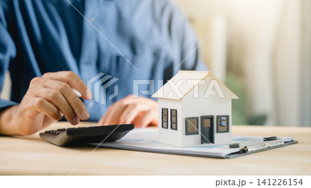 Mortgage loan interest rate payment signing real estate model planning property investment details involve person using calculator for bank home finance purchase budget analysis data Mortgage loan interest rate payment signing real estate model planning property investment details involve person using calculator for bank home finance purchase budget analysis data 141226154