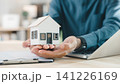Real estate contract for property mortgage finance approved, home insurance document protects homeowner and house tenant, investment strategy involves agent holding model house near laptop 141226169